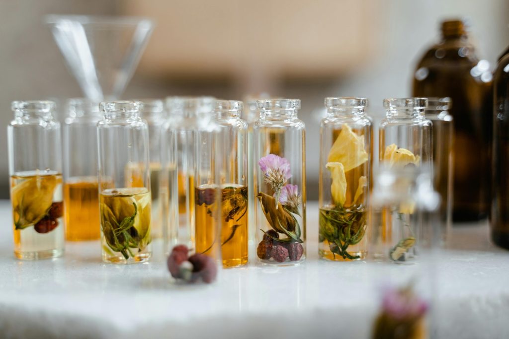 Sammlung von Glasflaschen mit getrockneten Blumen und Flüssigkeit, ideal für die Aromatherapie